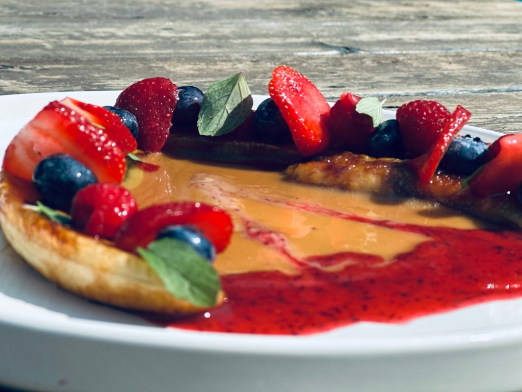 Bananes flambées au lait de coco, sauce framboises et fraises